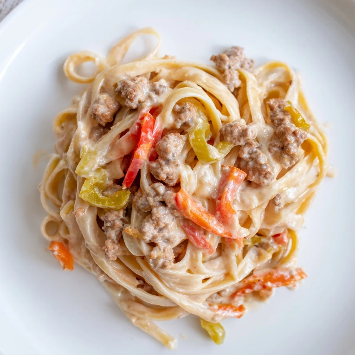 Creamy Pepper Ground Beef Fettuccine topped with colorful bell peppers and savory beef.