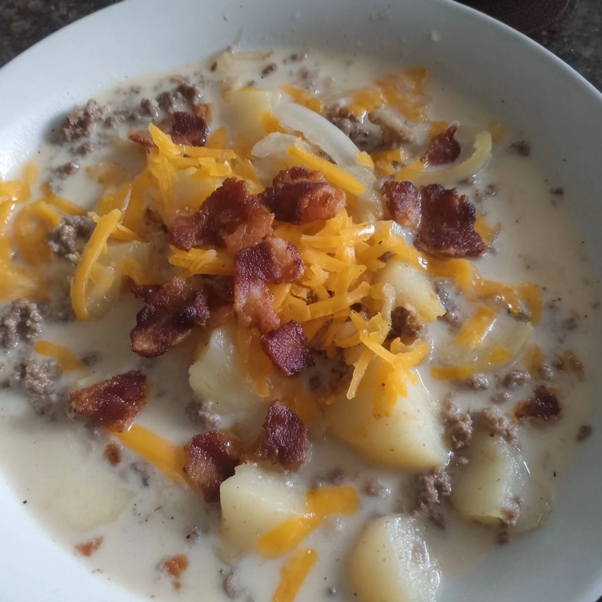 Close-up of a creamy Crockpot Cheeseburger Soup, showcasing tender potatoes and melting cheese over the beef.