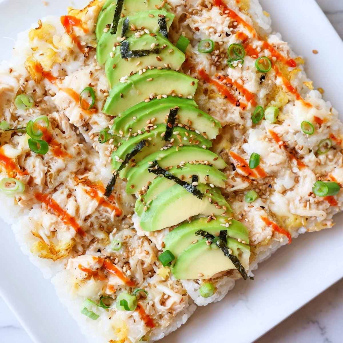 Golden-brown Chicken Sushi Bake sizzling from the oven, ready to serve with fresh avocado slices.