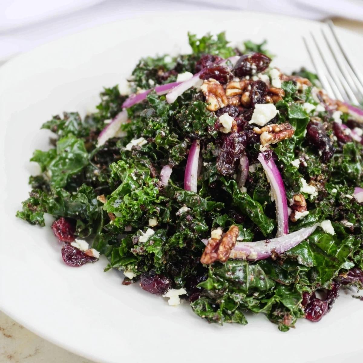 Freshly massaged curly kale with toasted walnuts, red onion, and cranberries in a warm maple mustard vinaigrette.