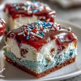 Delicious Patriotic Poke Cake, bursting with colorful gelatin and smooth white chocolate.