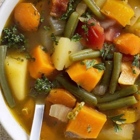 Warm bowl of Fall Vegetable Soup with bright vegetables, ready to serve.