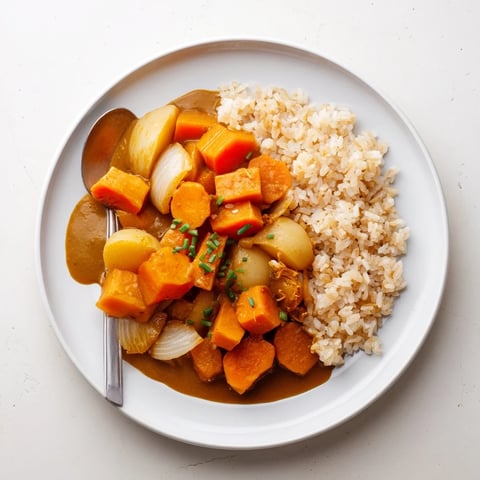 Roasted pumpkin glistens in savory Japanese curry sauce, creating a comforting dish.  