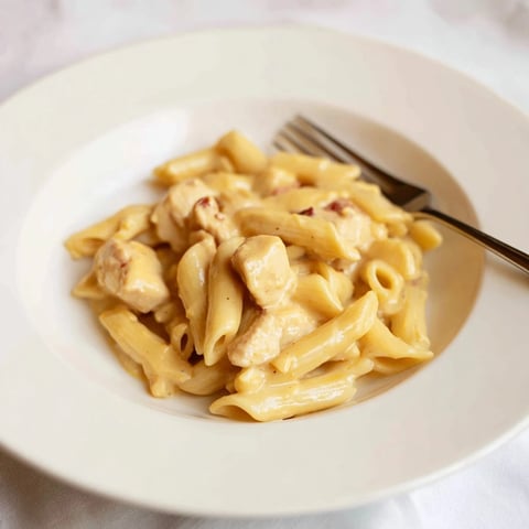Creamy honey mustard chicken pasta garnished with fresh herbs and vibrant colors.  