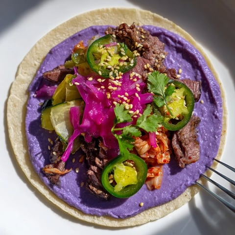 Vibrant Global Street-Food Fusion Tacos drizzled with colorful ube crema and fresh toppings.  