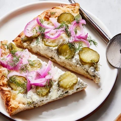 Tangy Pickle Pizza topped with creamy sauce, mozzarella, and crunchy dill pickles.  