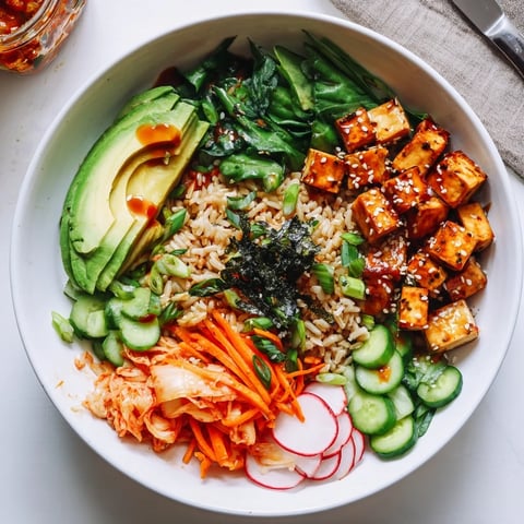 A colorful fermented vegetable bowl with kimchi, fresh veggies, and grains.  