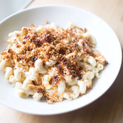 Classic Mac & Cheese with BBQ Chicken bubbling in a baking dish, a perfect family meal.