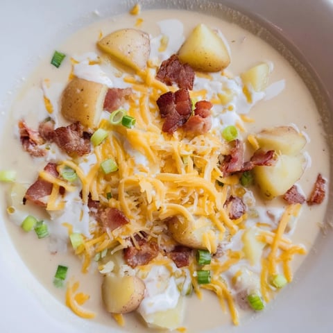 Crockpot Loaded Baked Potato Soup: a steaming bowl with crumbled bacon and creamy cheddar cheese.