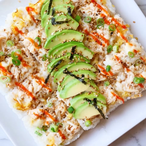 Golden-brown Chicken Sushi Bake sizzling from the oven, ready to serve with fresh avocado slices.