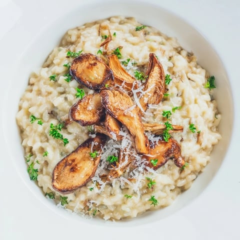 A serving of creamy Roasted Mushroom Risotto garnished with fresh parsley and extra Parmesan.  