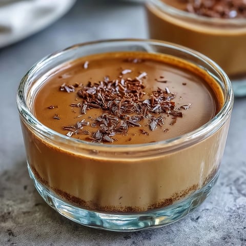 Creamy Hojicha Pudding topped with whipped cream in a glass ramekin, showcasing a silky roasted tea dessert.