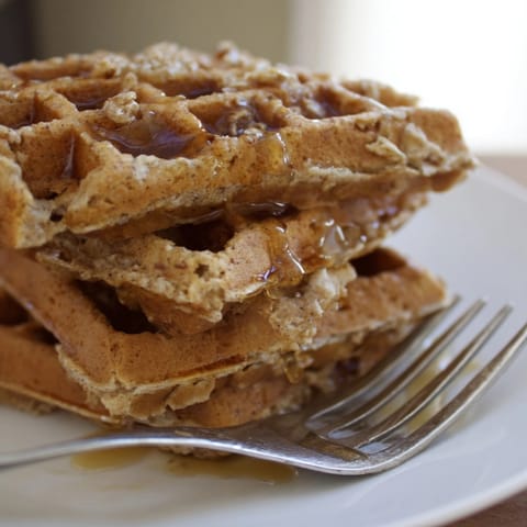 Crisp-edged Cinnamon Vanilla Oat Waffles steam gently, ready to be enjoyed for breakfast.