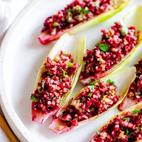 Tangy and spicy cranberry jalapeño salsa served in crunchy endive for a fresh appetizer.  