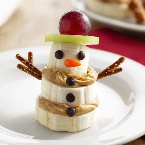 Creamy peanut butter holds these festive Banana Peanut Butter Snowmen together, perfect for a joyful snack.