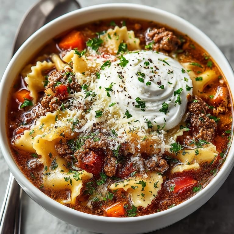 A steamy bowl of easy One-Pot Lasagna Soup, sprinkled with fresh basil garnish.