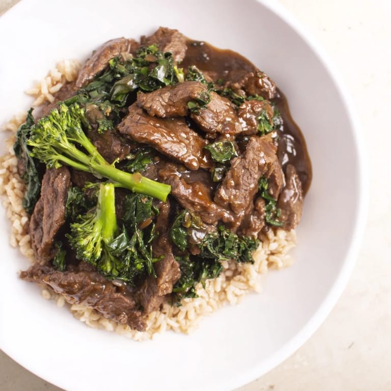 A steaming bowl of comforting Beef & Broccoli featuring savory sauce, ideal for any weeknight dinner.