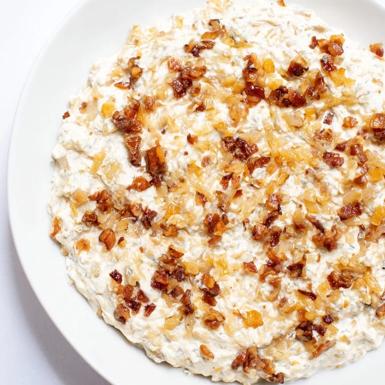 A creamy bowl of Caramelized Onion and Bacon Dip: imagine rich, savory onions and smoky bacon mingled.