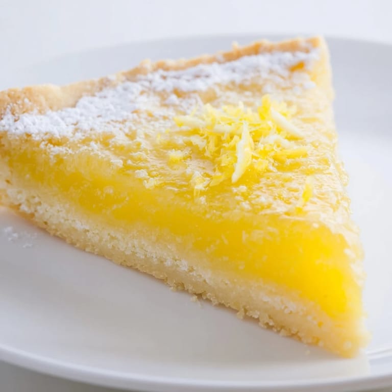 Freshly baked lemon bars, showcasing a buttery shortbread crust and a bright, citrus filling.