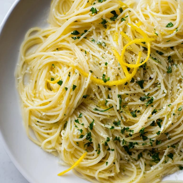 Elegant plate of Lemon Capellini, perfectly coated with a lemon butter sauce, ready to serve.