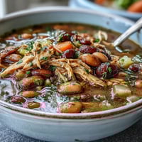 A steaming bowl of 15-bean crockpot soup with tender smoked turkey and colorful vegetables.  