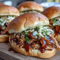 Juicy Honey Peach BBQ Chicken Sliders piled high on toasted buns.