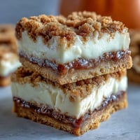 Golden Pumpkin Cheesecake Snickerdoodle Bars swirled with cinnamon sugar.